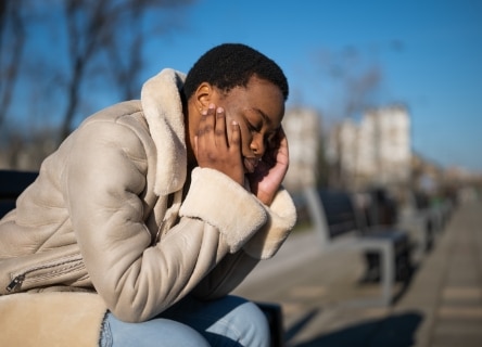depressed man visibly upset sitting on a bench