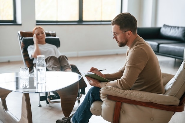 Woman is sitting in chair at an appointment with a psychologist.
