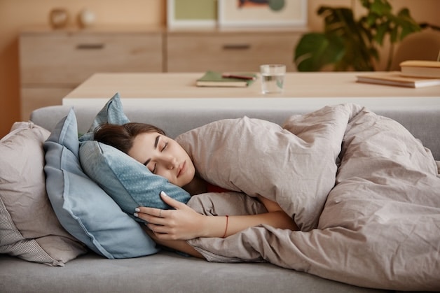 sad young lady laying on the couch.
