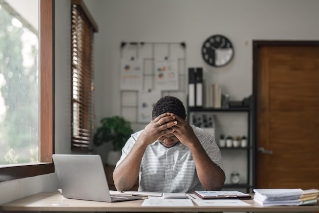 business man visibly upset looking at paperwork.