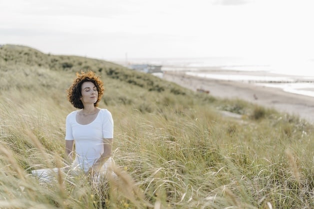 woman doing yoga at beach in the dunes.